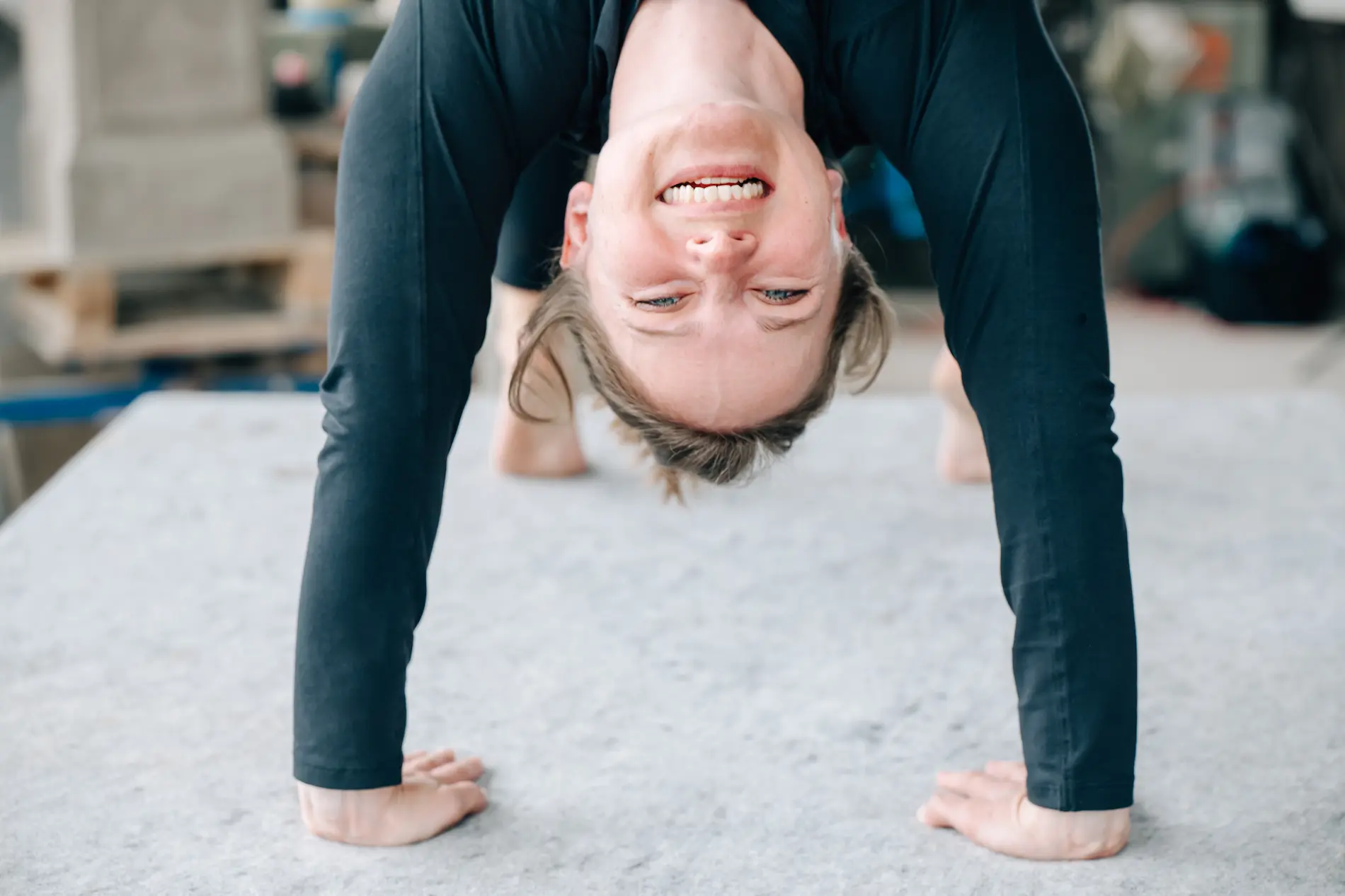 Frau Kopf über, lachend in Yogapose